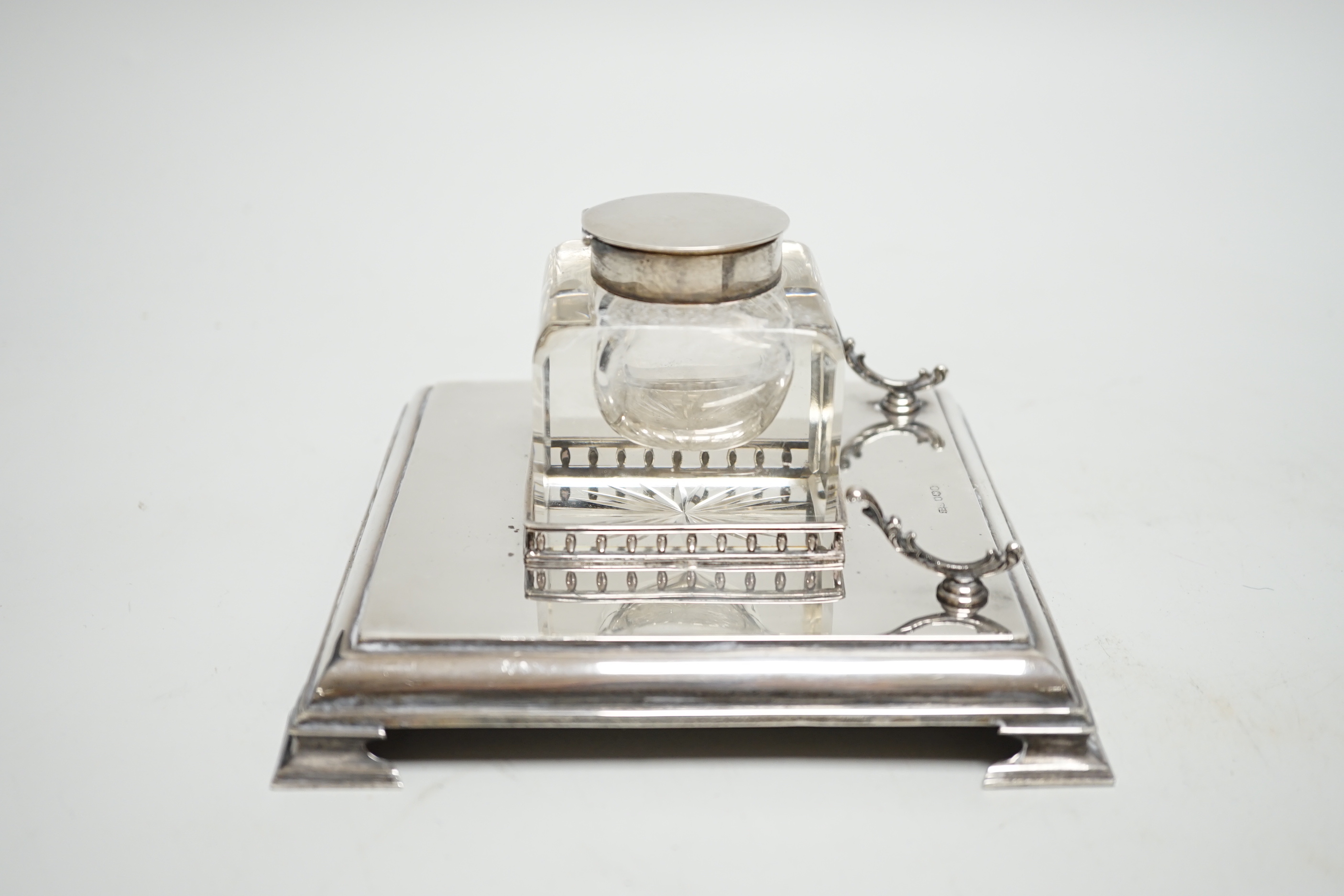 A George V silver inkwell, with mounted glass well and pen rest, James Dixon & Sons, Sheffield, 1928, 15.2cm, base 7.3oz.